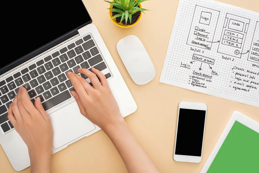 Wireframe skica web stranice s drvenim kockama na pastelnoj podlozi