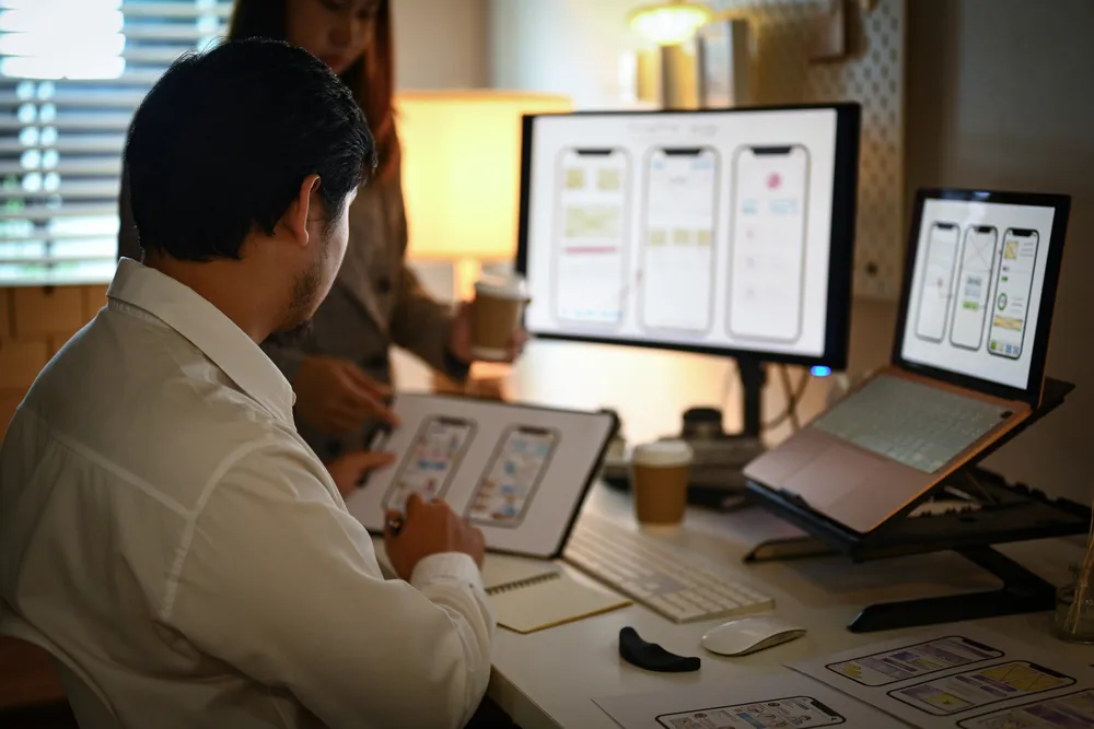Dizajner pregledava mockup mobilnih ekrana web stranice