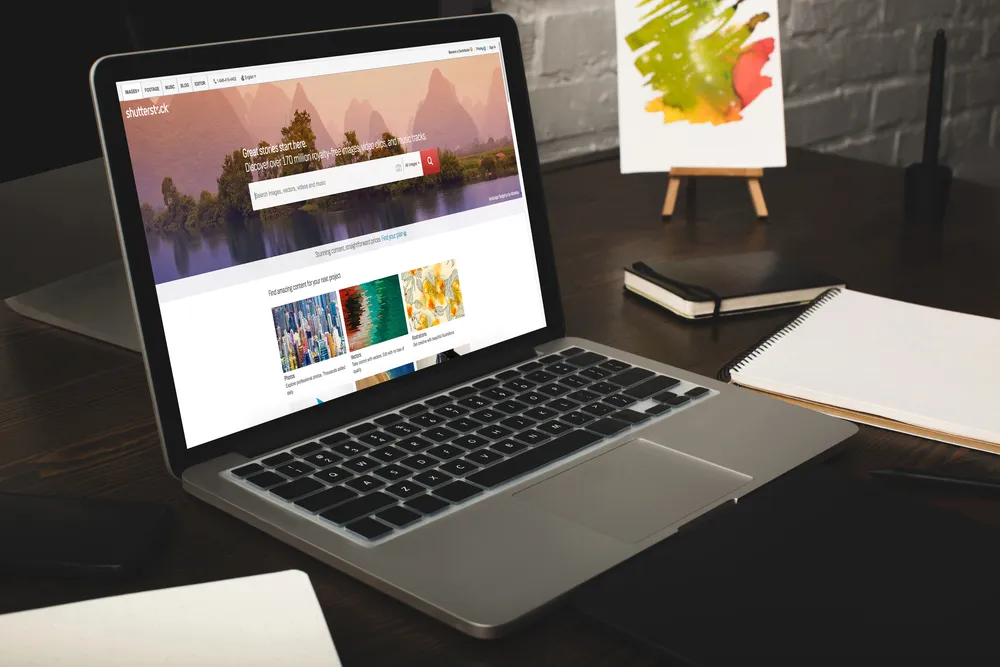 Web dizajner radi za laptopom na drvenom stolu
