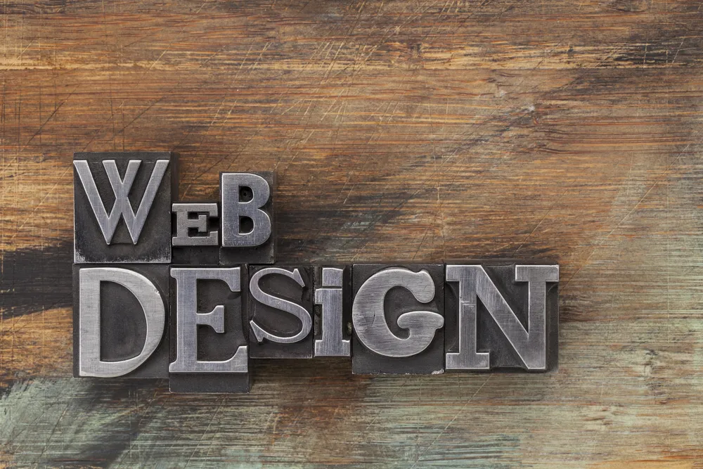 Riječi web design složene metalnim tiskarskim slovima na drvenoj podlozi